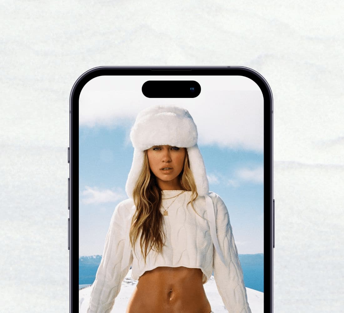 La mannequin prend la pose avec un chapeau en fausse fourrure blanche, un chandail blanc écourté et un pantalon de jogging blanc.