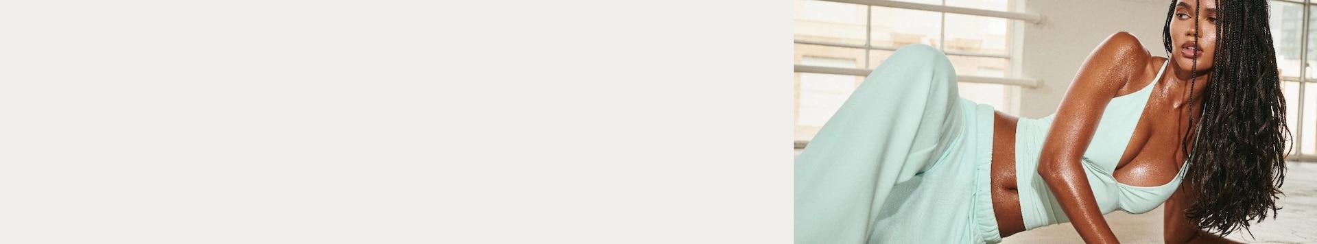 La mannequin prend la pose dans une camisole vert menthe et un pantalon de jogging assorti.